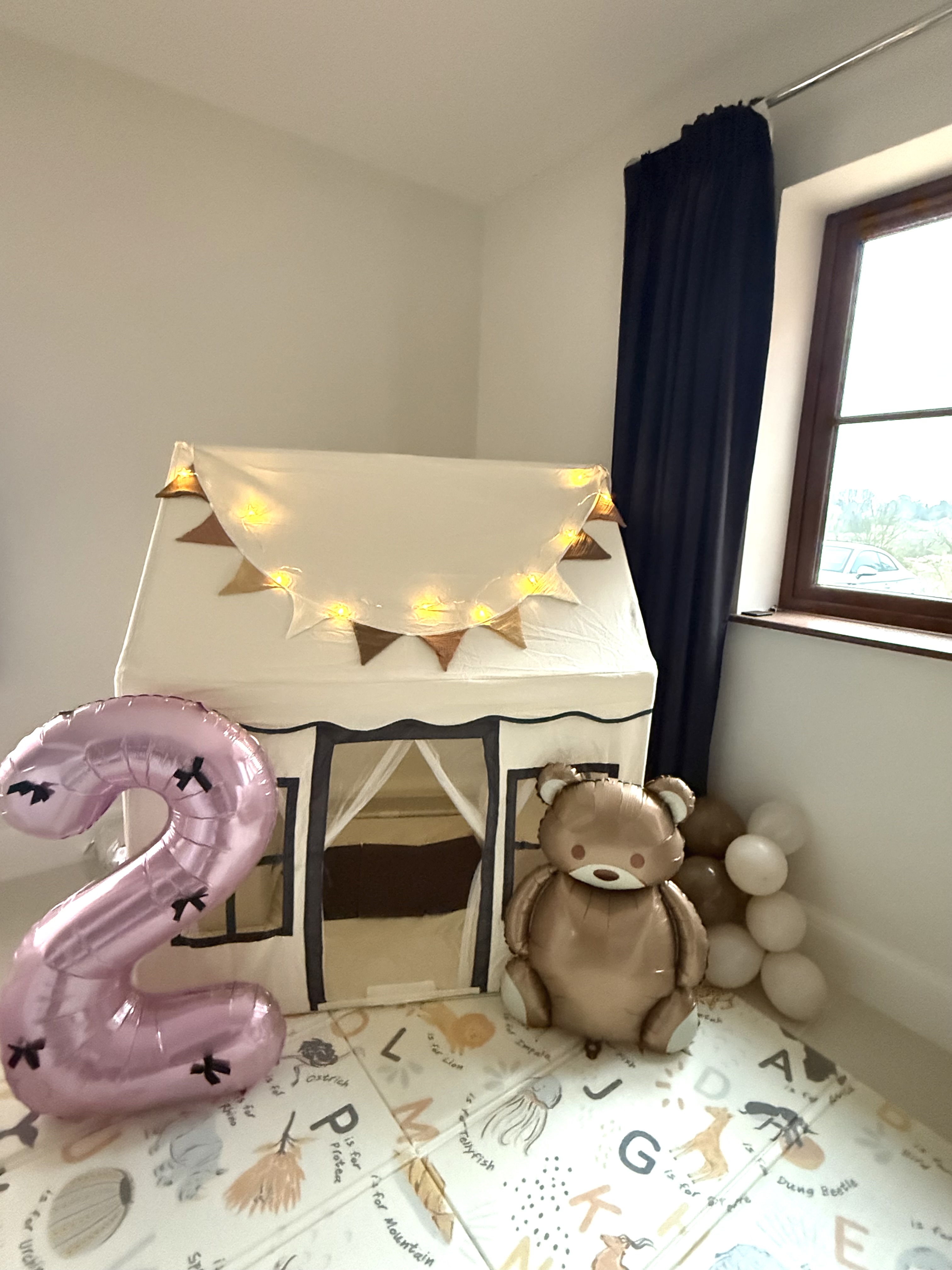 Playhouse set up live with fairy lights and balloons